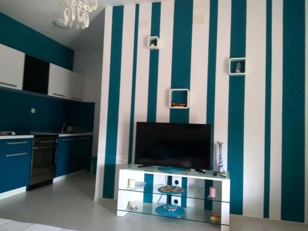 a living room with a tv and a striped wall at Apartment Tara in Sumartin