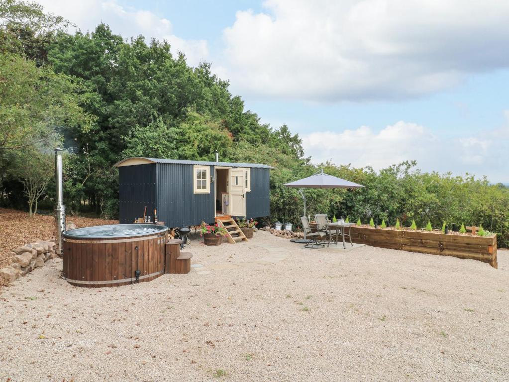 ein winziges Haus mit Whirlpool im Hof in der Unterkunft High Grounds Shepherd's Hut in Ashbourne