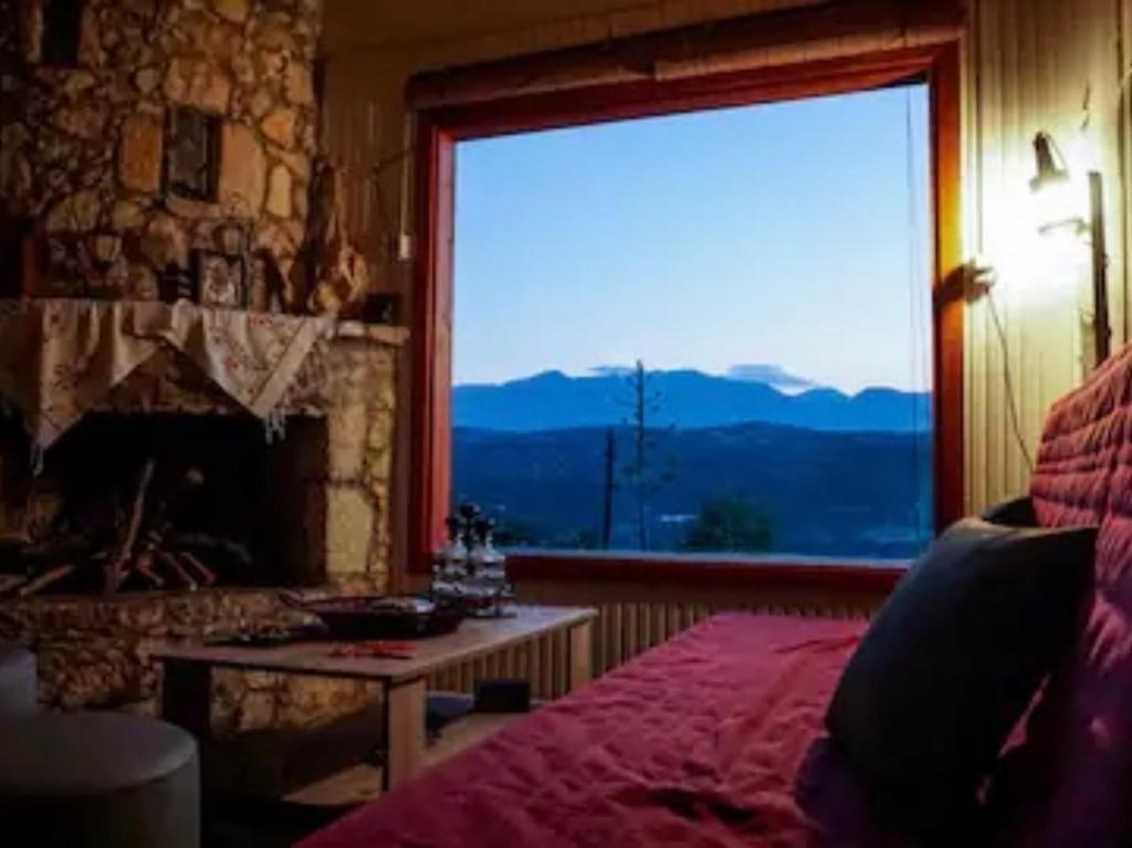Quiet little country house with breathtaking view في Áyios Síllas: غرفة نوم بها موقد ونافذة مطلة
