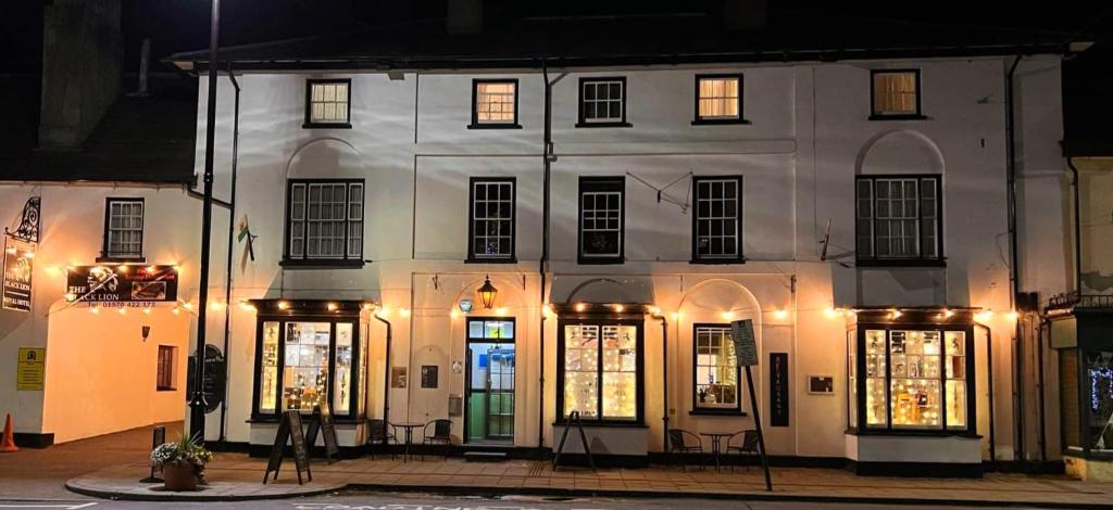 um edifício branco com janelas iluminadas à noite em The Black Lion Royal Hotel em Lampeter