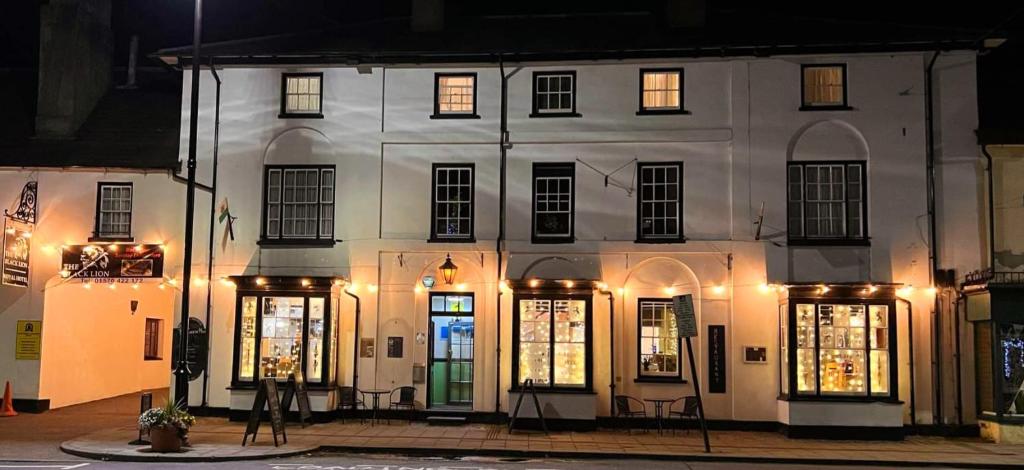 a white building with lit up windows at night at The Black Lion Royal Hotel in Lampeter
