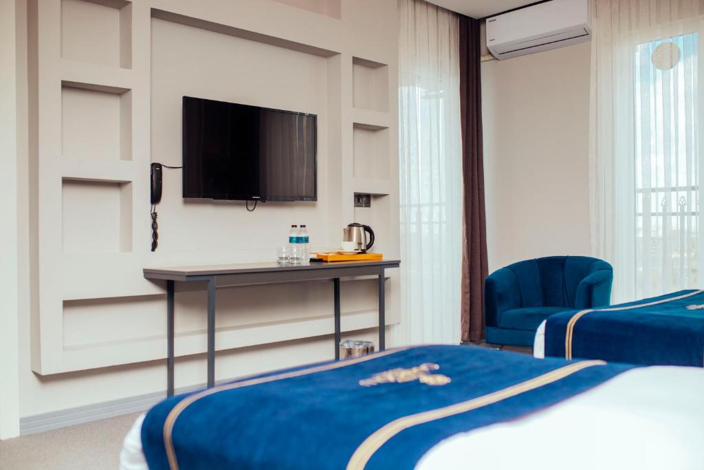 - une chambre avec un lit, un bureau et une télévision dans l'établissement GRAND ÇAKIROĞLU HOTEL, à Aksaray
