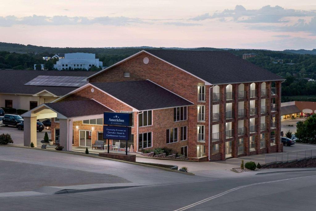 een groot bakstenen gebouw met een bord ervoor bij AmericInn by Wyndham Branson & Conference Center in Branson