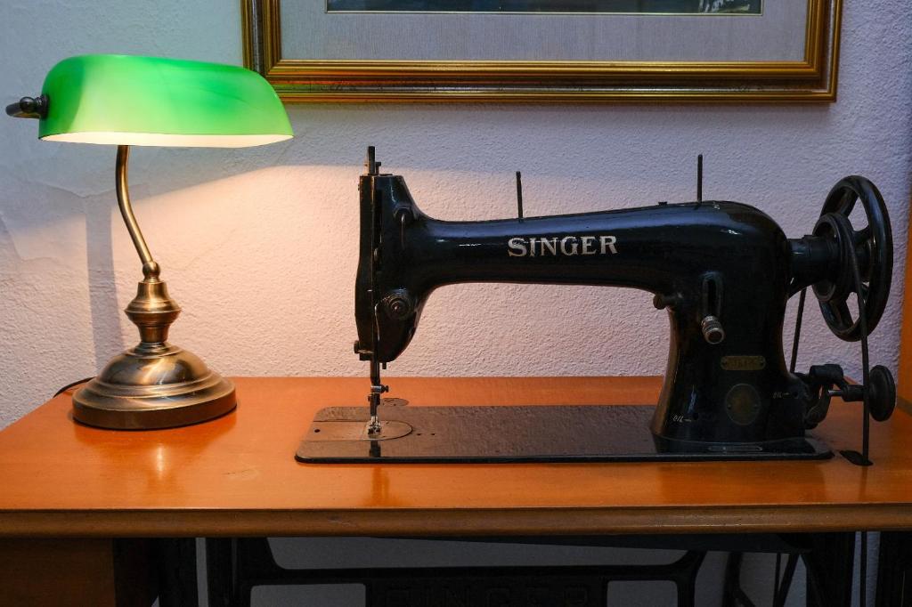 una macchina da cucire seduta su un tavolo accanto a una lampada di La casa di zia Imma nel dirupo a Pisticci