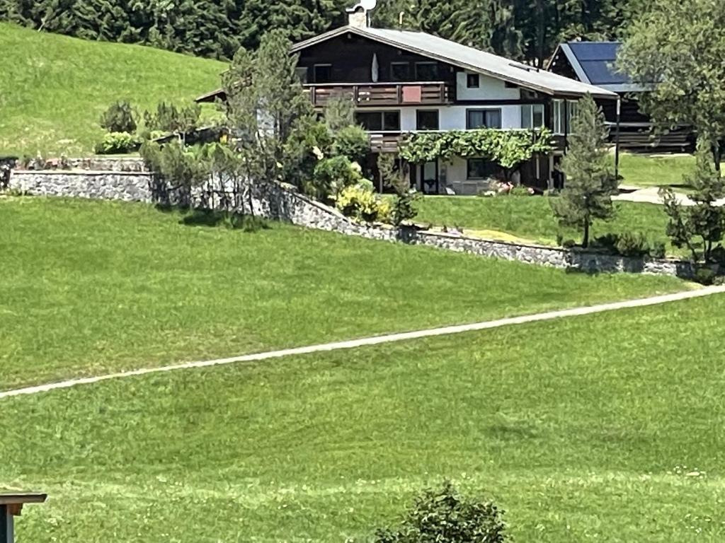 una casa sentada en la cima de un campo verde en Fewo 2 am Auweg, en Hirschegg