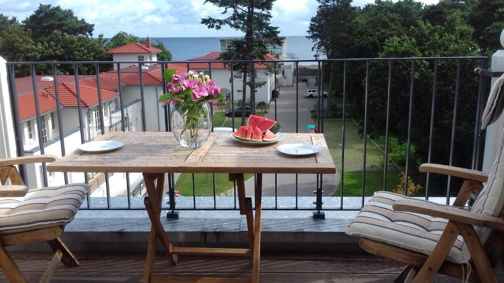 a table with a vase of flowers on a balcony at Baabe Villa Andrea Ferienwohnung P in Baabe