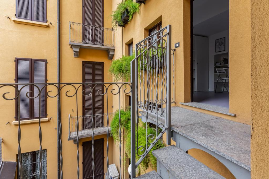 um edifício de apartamentos com uma varanda com plantas em Central Studio APTS Milano-Corso Magenta em Milão