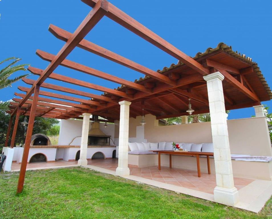a wooden pergola with a table on a patio at Luxury Zante Villa Zante Vista Villa Private Pool Seaviews Agios Sostis in Laganas