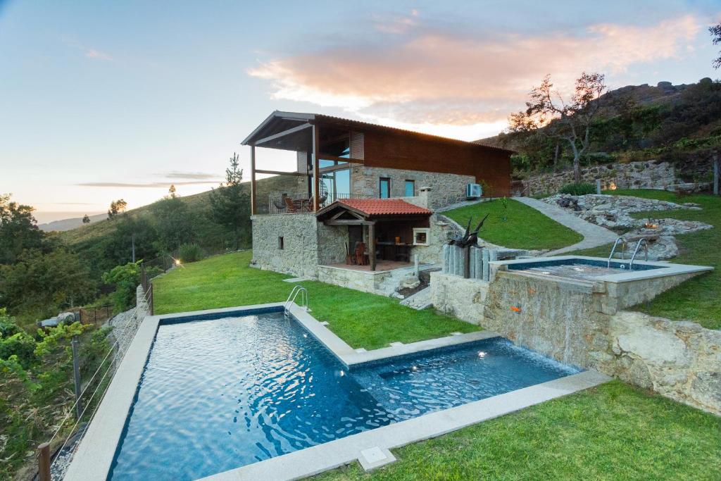 an exterior view of a house with a swimming pool at HUGS Nature Retreat Heated Pool & Jacuzzi in Vila Verde