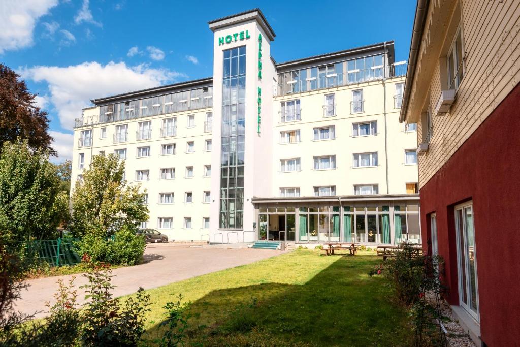 un gran edificio blanco con un parque enfrente en ALPHA HOTEL Hermann von Salza, en Bad Langensalza