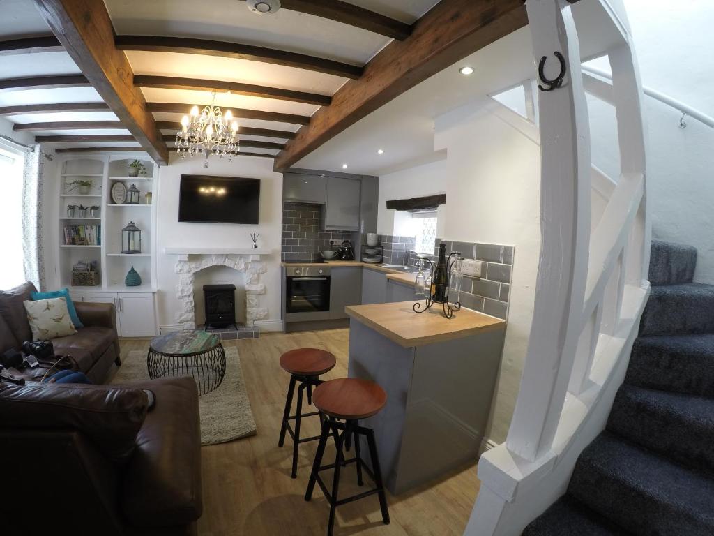 a kitchen and living room with a staircase and a living room at Daisy Cottage in Wakefield