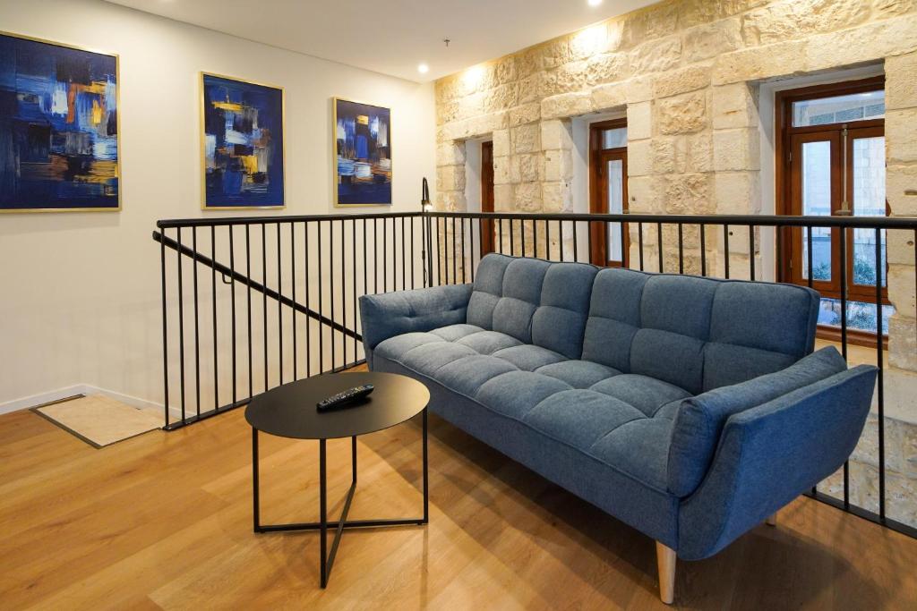 un soggiorno con divano blu e tavolo di Urbanic Apartments a Gerusalemme