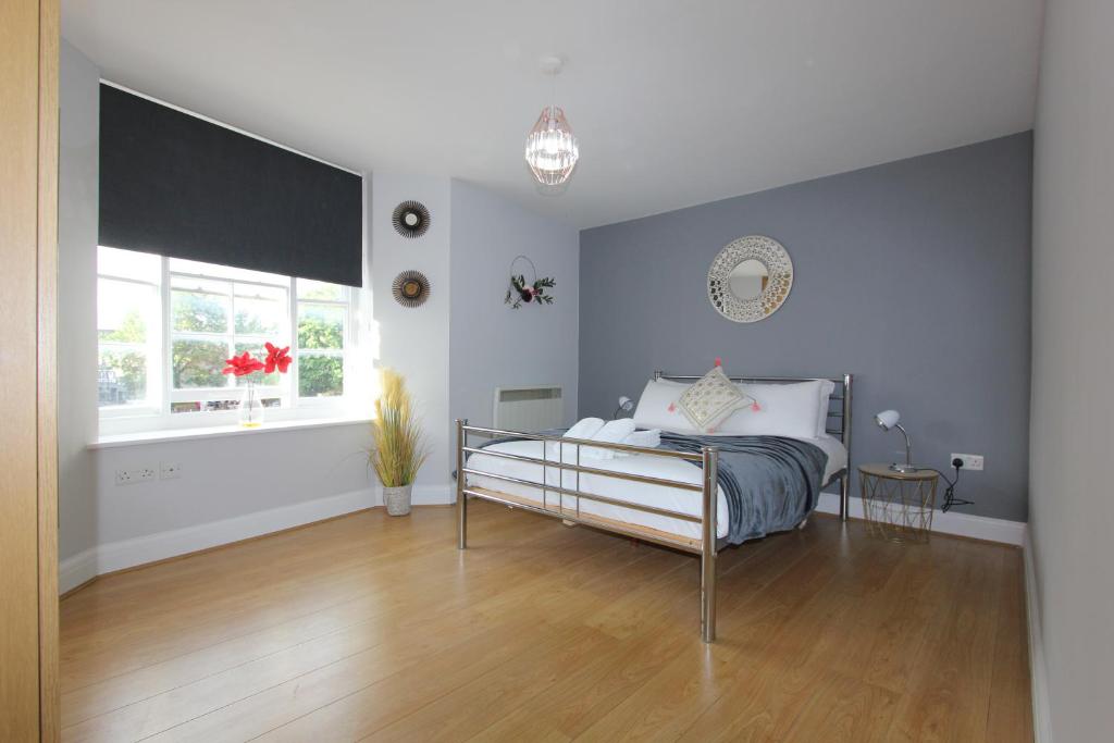 a bedroom with a bed and a window at Lovely 2 Bed 2 Bath Flat & Parking by CozyNest in Reading