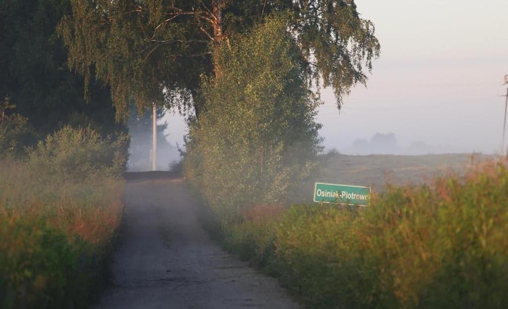 a road with a green sign on the side of it at Stara Stolarnia in Ruciane-Nida