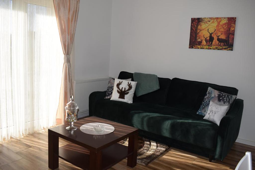 a living room with a green couch and a table at Apartman Bambi in Vojnić