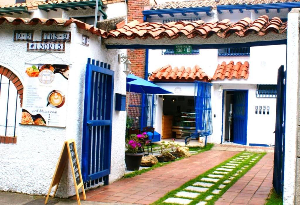 um edifício branco com portas azuis e um pátio em Aloha Hostel em Bogotá