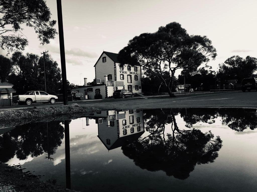 a reflection of a house in a puddle of water at Flinders Ranges Motel - The Mill in Quorn