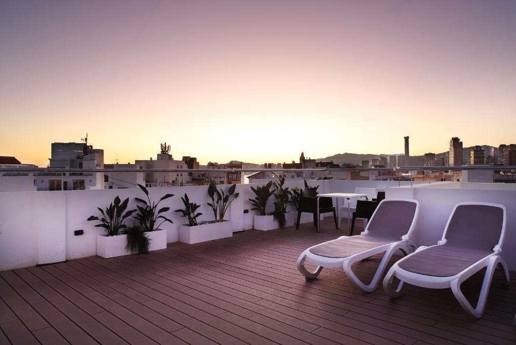 d'un balcon sur le toit avec des chaises et des tables. dans l'établissement Hotel Alameda, à Benidorm