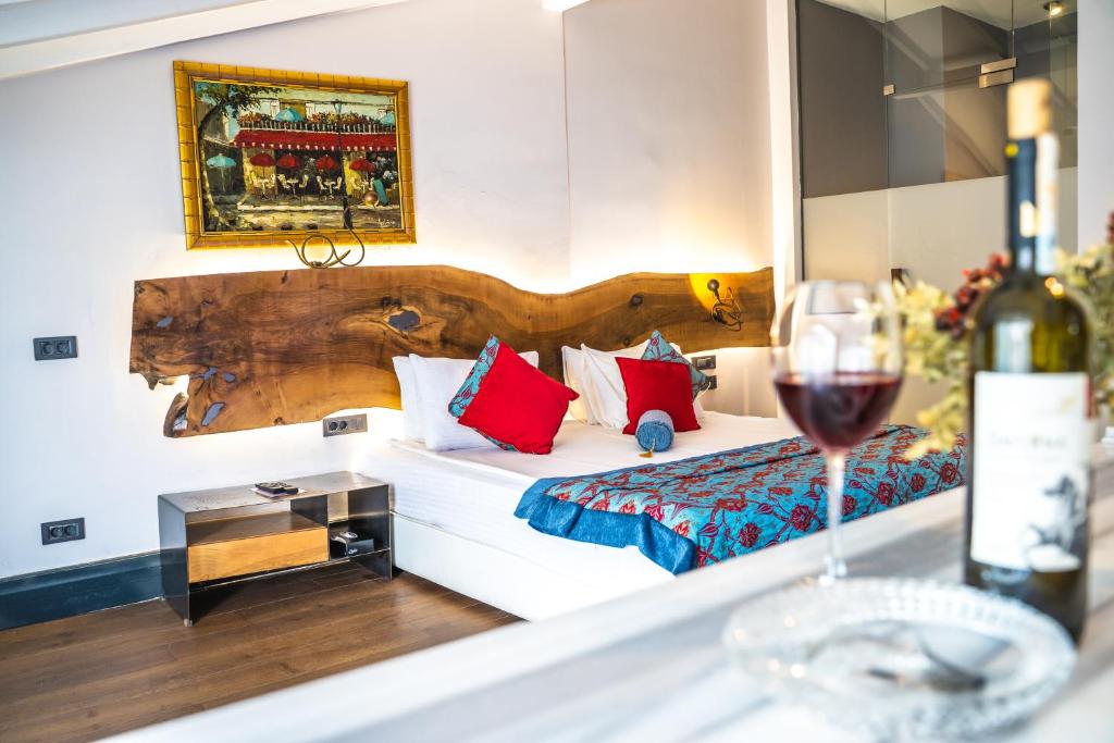 una camera d'albergo con letto e un bicchiere di vino di West Pera Hotel a Istanbul