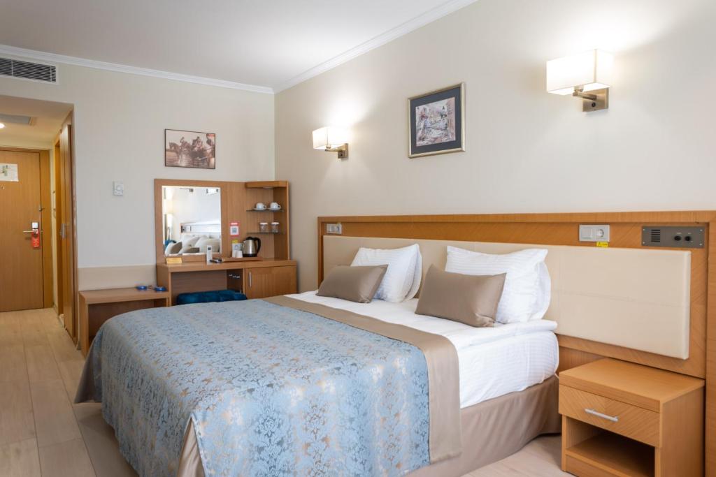 una camera d'albergo con un letto grande e uno specchio di Patalya Lakeside Resort Hotel a Golbası
