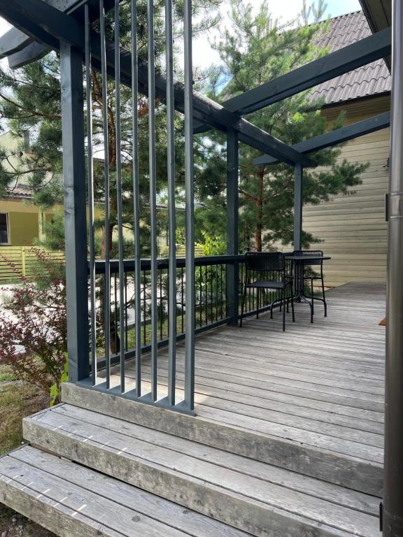 a deck with a table and benches on it at Rugio namai-Rye house in Palanga