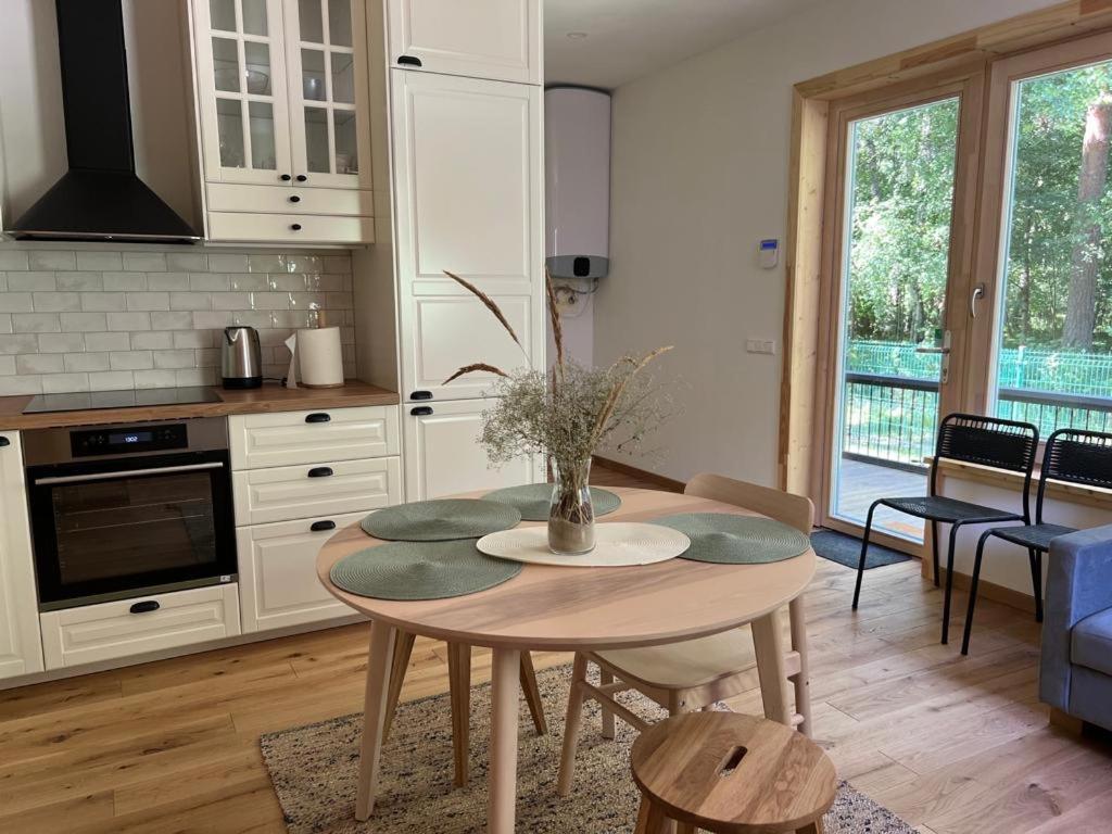 a kitchen with a table with a vase on it at Rugio namai-Rye house in Palanga