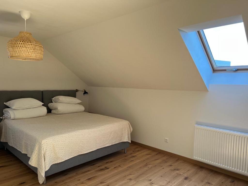 a bedroom with a bed with two pillows and a window at Rugio namai-Rye house in Palanga