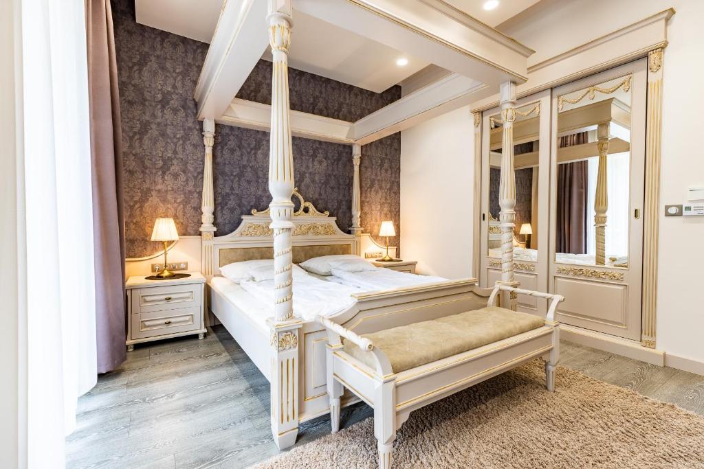 a bedroom with a four poster bed and a mirror at Degenfeld Kastély Tóparti Vendégház in Téglás