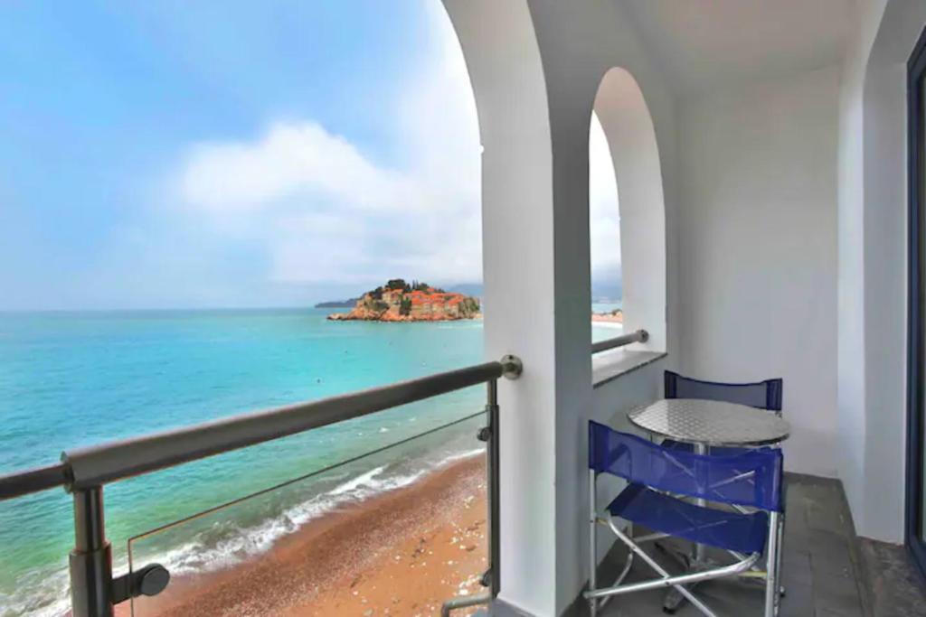 einen Balkon mit einem Tisch und Meerblick in der Unterkunft Plava Vila Beach Apartments Sveti Stefan in Sveti Stefan