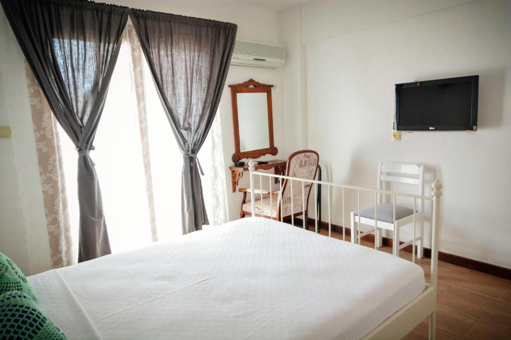 1 dormitorio con 1 cama, TV y ventana en Parva Port, en Alacati