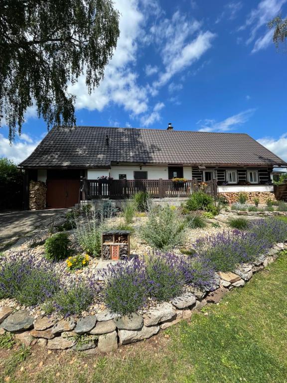 un jardín frente a una casa con flores en Chalupa u Břízek, en Dolní Branná