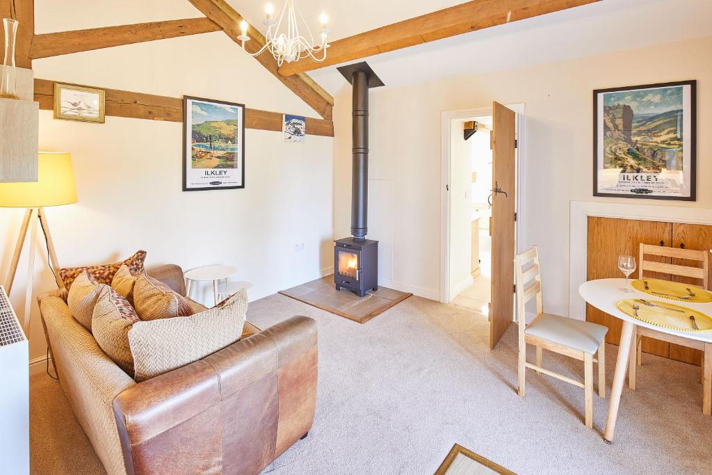 a living room with a couch and a wood stove at Host & Stay - The Hayloft in Ilkley