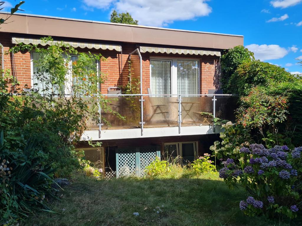 een stenen huis met een balkon in de tuin bij Haus Ekke Nekkepenn II, Haus Ekke Nekkepenn II, Whg C2 in Wyk auf Föhr