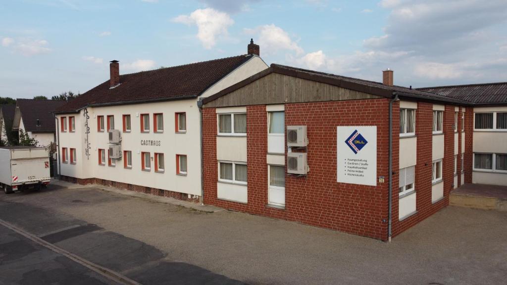 un bâtiment rouge et blanc avec un parking dans l'établissement Dill Hotel, à Ilsede