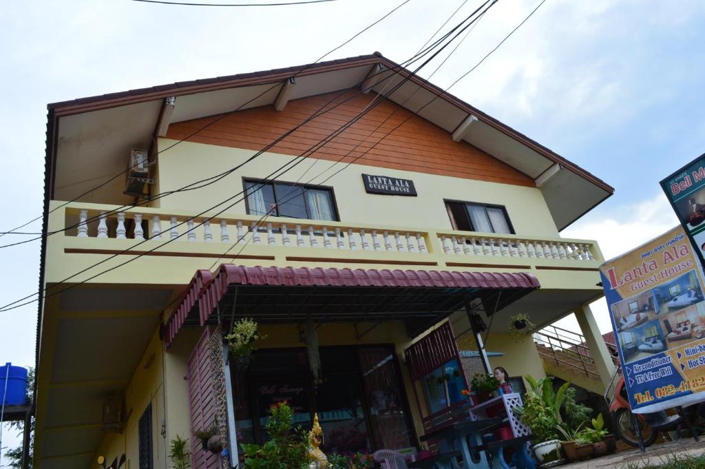 una casa gialla con tetto arancione di Lanta Ala Guest House a Phra Ae beach