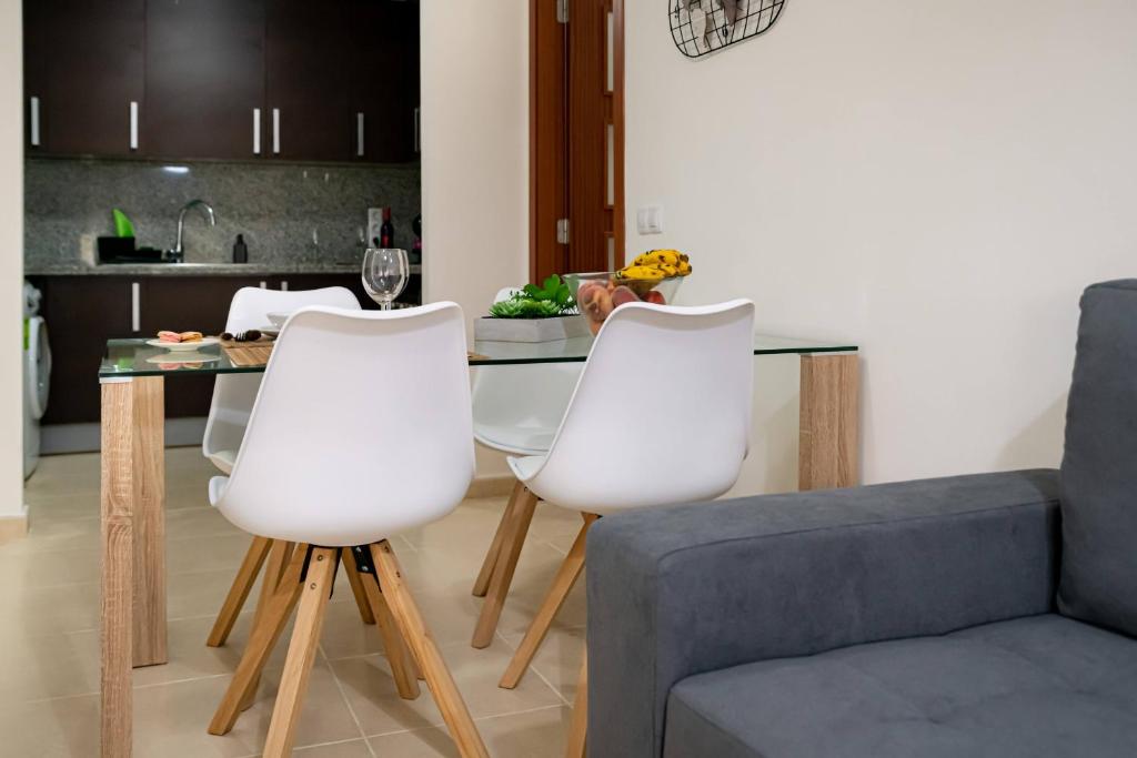 een woonkamer met een tafel en drie witte stoelen bij Apartamento La Folía in Icod de los Vinos