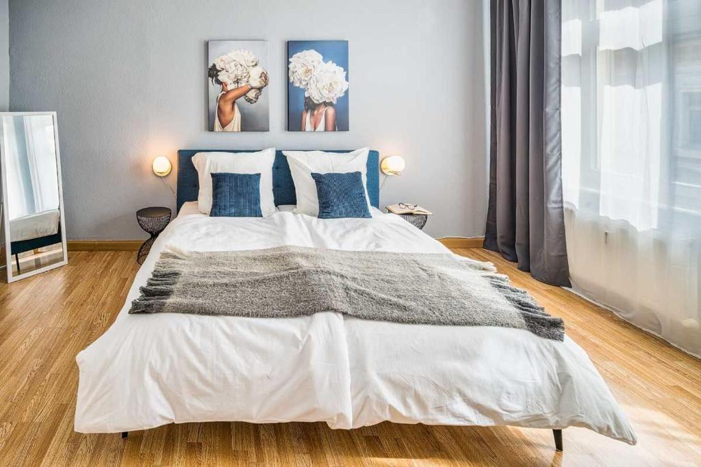una camera da letto con un grande letto bianco con cuscini blu di cozy Apartment SOLARIS in Meißen Altstadt Netflix a Meißen