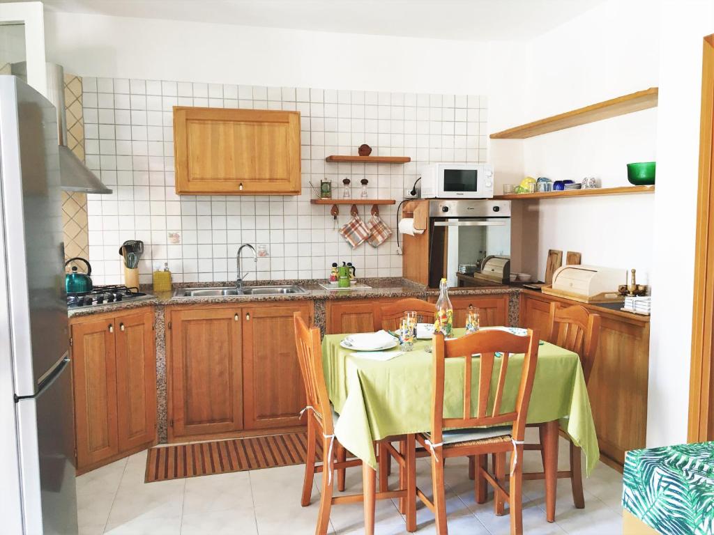 een keuken met een tafel met een groene tafelkleed bij Bougainvillea Bank in Monserrato