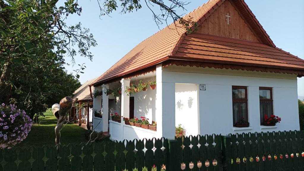 een klein wit huis met een bruin dak bij Guesthouse Tulipán Vendégház 