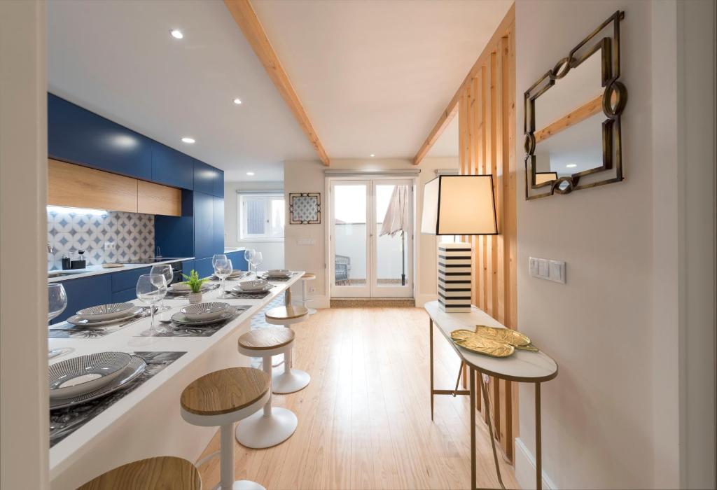 a kitchen with a long counter and stools in a room at Porta do sol Luxury Apartment in Porto