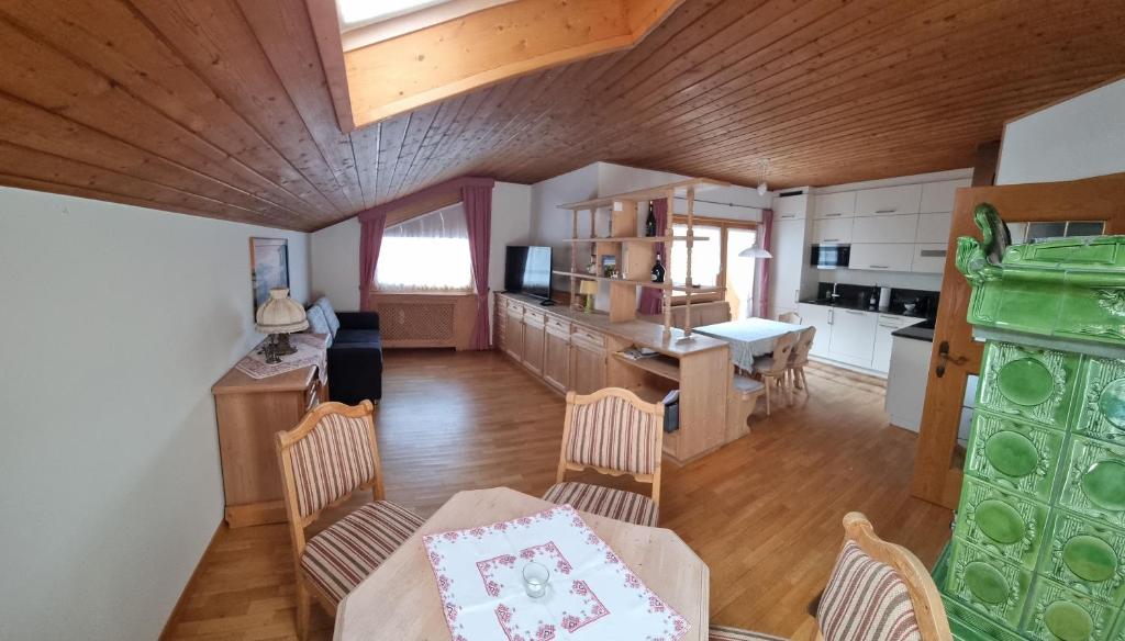 Schlernwohnung in Seis am Schlern في سويسي: مطبخ وغرفة معيشة مع طاولة وكراسي