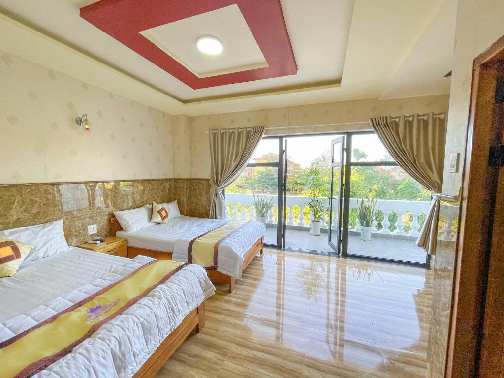 een hotelkamer met 2 bedden en een balkon bij Khách sạn Triều Dâng in Liên Trì (4)