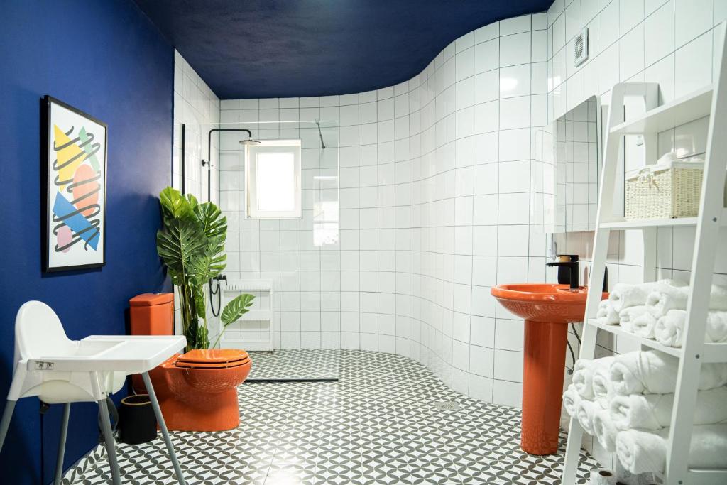 uma casa de banho com paredes azuis e um WC e um lavatório. em Artament Prishtina em Pristina