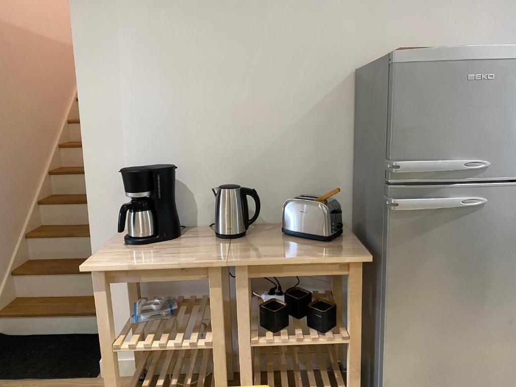 a kitchen with a table with a refrigerator at Le ker Maclow in Saint Malo