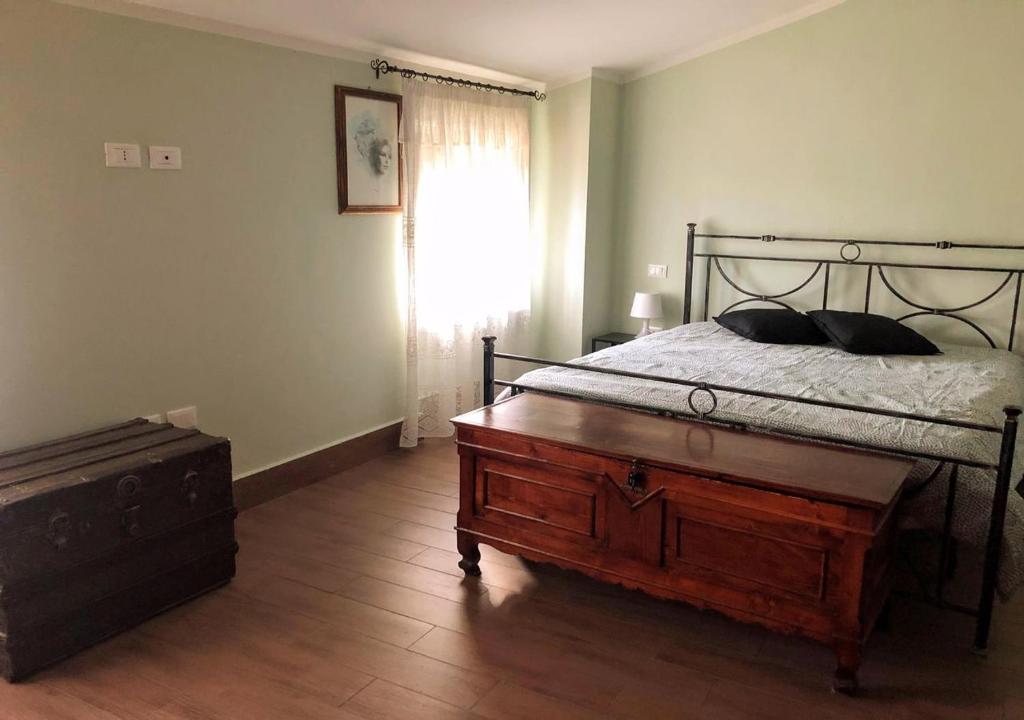 una camera con un letto, un comò in legno e una finestra di Un Piccolo Rifugio a San Potito