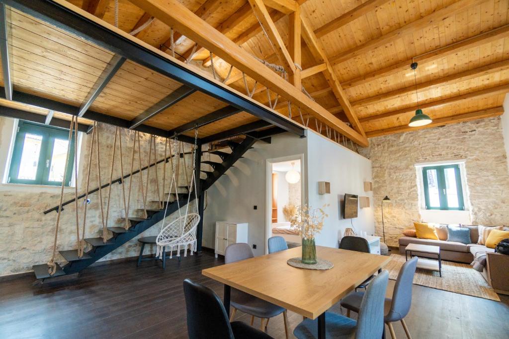 a living room with a wooden table and a staircase at Corfu Pigeon Nest in Corfu