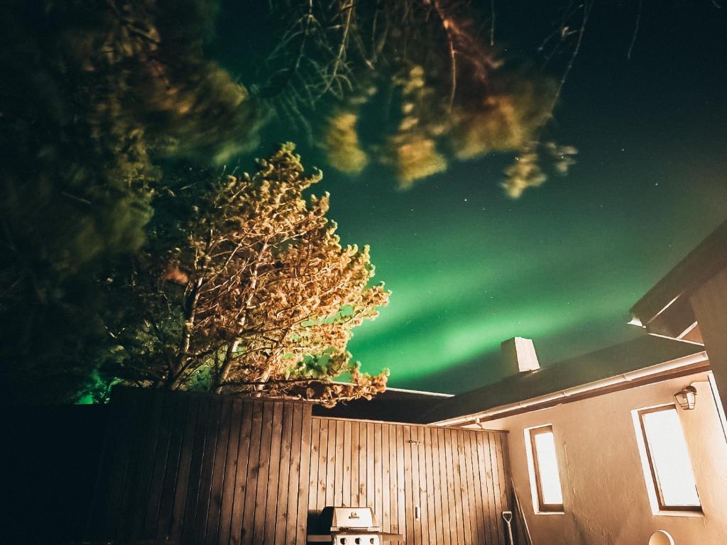 una imagen de la aurora en el cielo sobre una valla en Hellatún Guest House!, en Hella