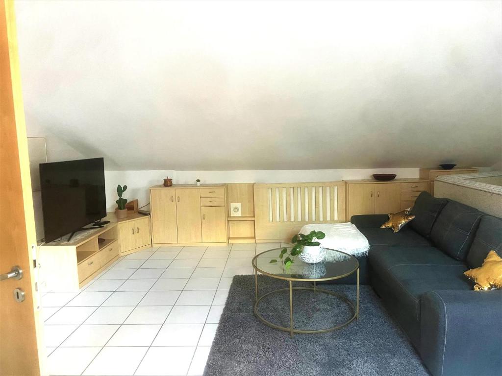 a living room with a blue couch and a table at Möblierte 3 Zimmer Apartment - Mit Smart TV, Wlan und kostenfreie Parkplätze in Schloß Holte-Stukenbrock