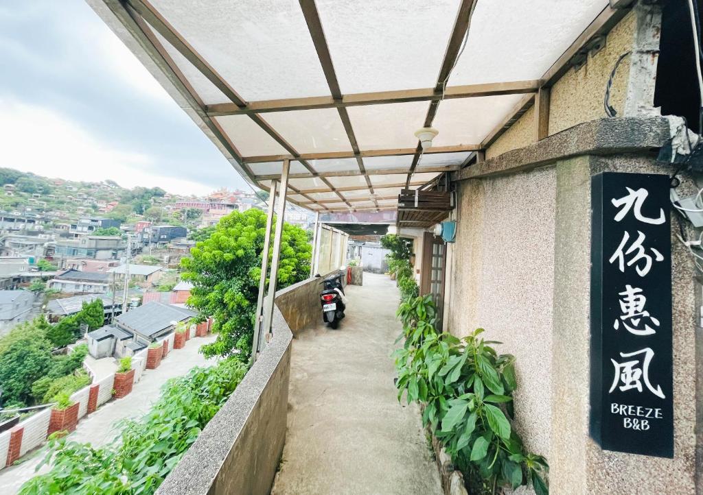 a building with a sign on the side of it at Jiufen Breeze 九份惠風民宿ｌ6人包棟小屋 in Jiufen