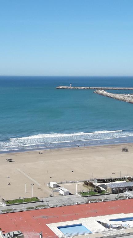 a view of a beach with the ocean and a pier at Playa Grande Studio Golf y Playa in Mar del Plata